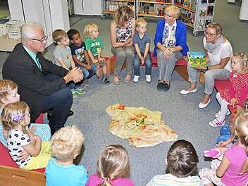 Die Welt der Bücher: Sabine Dittmar (hinten rechts) las als Lesepatin im Bibliotheks- und Informationszentrum Haßfurt vier- und fünfjährigen Kindern vor. Mit im Bild die Leiterin der Bücherei, Annelie Ebert (hinten, Zweite von rechts), die Leiterin des Kindergartens, Gisela Kaffer (Dritte von rechts) und Bürgermeister Günther Werner (links).  Foto: Ulrike Langer