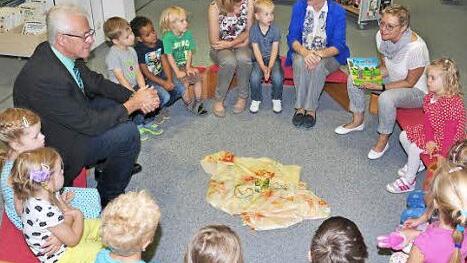 Die Welt der Bücher: Sabine Dittmar (hinten rechts) las als Lesepatin im Bibliotheks- und Informationszentrum Haßfurt vier- und fünfjährigen Kindern vor. Mit im Bild die Leiterin der Bücherei, Annelie Ebert (hinten, Zweite von rechts), die Leiterin des Kindergartens, Gisela Kaffer (Dritte von rechts) und Bürgermeister Günther Werner (links).  Foto: Ulrike Langer