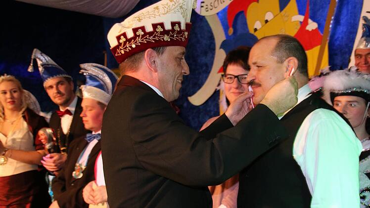 Alexander Maisel vom Fastnacht-Verband Franken legt Immo Küchler den Orden um. Foto: Bettina Knauth