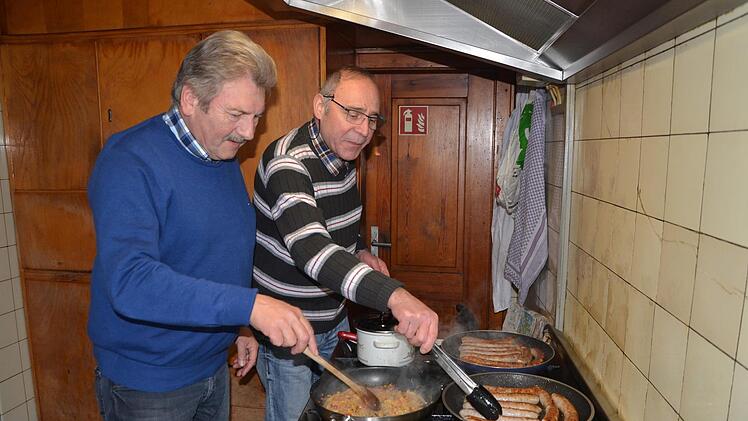 Bernhard Schwab (links) und Hans Heller bereiten die Serbischen Bratw&uuml;rste zu.