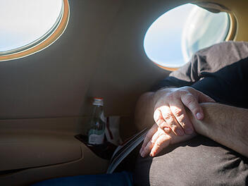 &Uuml;bergewichtige Passagiere, doppelte Sitzplatzpflicht, Southwest Airlines, Flugreisen, Sitzplatzregelung, Komfort, Sicherheit, R&uuml;ckerstattung, Economy Class, Armlehnen, Thromboserisiko, diskriminierend, Kanada, zweite Sitzplatzbuchung, Flugticketkosten. A big man sitting on a plane seat with hands crossed on a belly