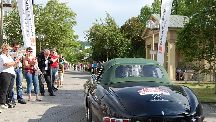 Oldtimerfans säumen die Kurhausstraße und fotografieren die an ihnen vorbeifahrenden Automobile. Foto: Sigismund von Dobschütz