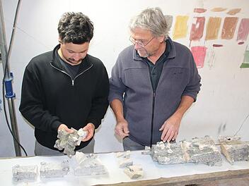 Lucian und Clemens Muth besprechen in ihrer Werkstatt in Unterneuses das Restaurieren der heruntergefallenen und  zerbrochenen Kalkstein-Fiale vom Regensburger Rathauserker. Foto: Matthias Einwag