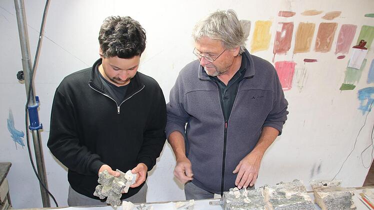 Lucian und Clemens Muth besprechen in ihrer Werkstatt in Unterneuses das Restaurieren der heruntergefallenen und  zerbrochenen Kalkstein-Fiale vom Regensburger Rathauserker. Foto: Matthias Einwag