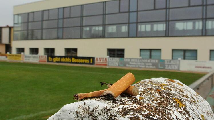 Wohin mit den Rauchern bei Großveranstaltungen in der Sander Turnhalle? Hier unten am Fußballplatz ist das auch so eine Sache, denn das wertvolle Rasenspielfeld sollte nicht beschädigt werden. Doch oben auf dem Parkplatz vis a vis der Anlieger stören die bis zu 100 Mann, die bei einem Event mal schnell Luft schnappen und eine rauchen wollen. Durch die Türen dringt der Lärm nach draußen, und auch sonst bringt das Getriebe Unruhe in die ruhige Wohngegend. Der Gemeinderat wird in Sachen Turnhall...