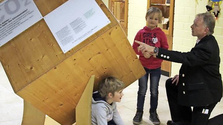 Leni und Sonja schauen sich den Würfel von allen Seiten an. Ganz schön viel Holz - da sind sich beide einig. Mit im Bild Günter Stenglein Foto: Katharina Müller-Sanke