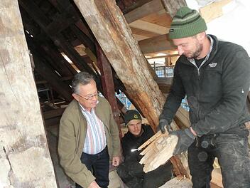 Entdeckten jetzt einen verborgenen Schaden im Mauerwerk: Die Zimmerleute Markus Herold und Jan Hargens (von rechts) begutachten mit Kirchenpfleger Franz Frosch (links) morsche Holzbalken.  Foto: Tobias Braunersreuther