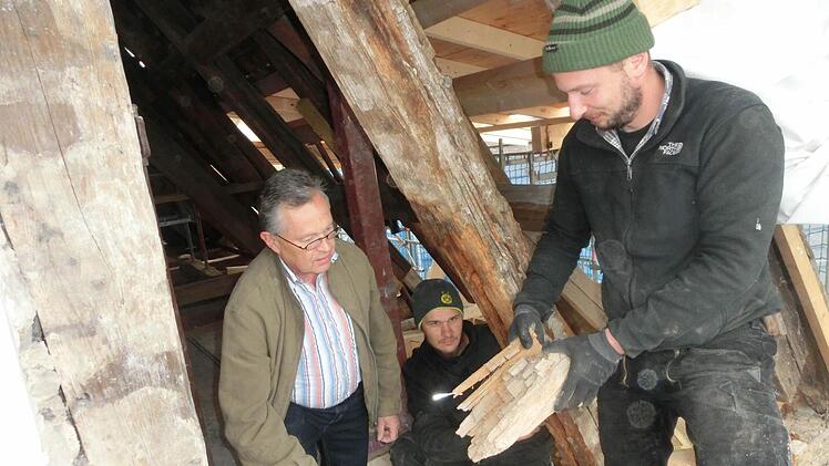 Entdeckten jetzt einen verborgenen Schaden im Mauerwerk: Die Zimmerleute Markus Herold und Jan Hargens (von rechts) begutachten mit Kirchenpfleger Franz Frosch (links) morsche Holzbalken.  Foto: Tobias Braunersreuther