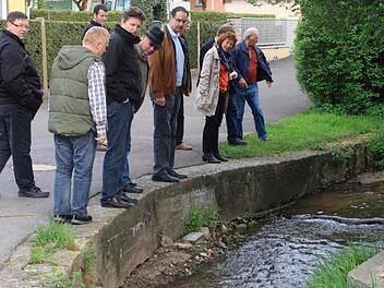 Ortsbegehung: Der Sambach wäscht die Uferbefestigung im Mühlenweg aus.  Foto: G. Bauer