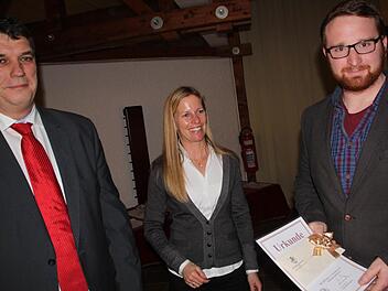 Florian Wagner erhielt von Zweitem Bürgermeister Hans Josef Stich und Dritter Bürgermeisterin Sabine Scheer bei der Jahresschlusssitzung des Stadtrates im Foyer der Adam-Riese-Halle eine Ehrenurkunde der Stadt für seinen hervorragenden Ausbildungsabschluss überreicht. Foto: Matthias Einwag