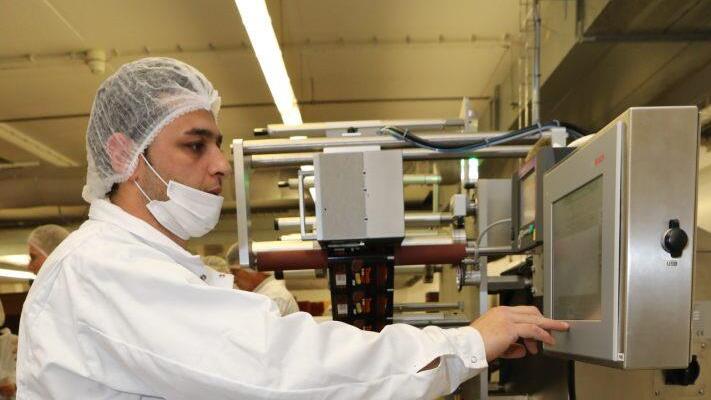 Mitarbeiter Shivan Seitz beim Verpacken von Erdnussbutter-Cups Foto: Barbara Herbst