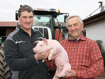 Nicht nur eines der jährlich mehr als 14 000 Ferkel, sondern gleich den ganzen Hof übergibt Kurt Selbert (rechts) seinem Sohn Stefan im kommenden Jahr. Der Junior hat sich bei der Bewirtschaftung eines abgespaltenen Betriebes bereits seit Jahrzehnten bewährt. Foto: Ralf Ruppert