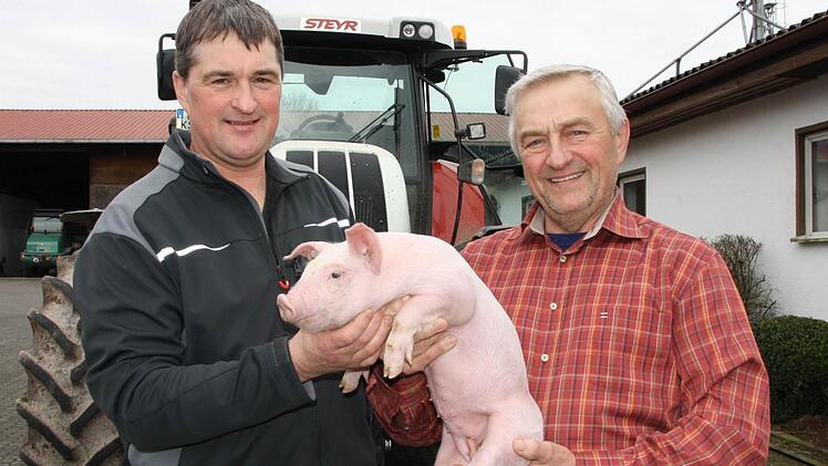 Nicht nur eines der jährlich mehr als 14 000 Ferkel, sondern gleich den ganzen Hof übergibt Kurt Selbert (rechts) seinem Sohn Stefan im kommenden Jahr. Der Junior hat sich bei der Bewirtschaftung eines abgespaltenen Betriebes bereits seit Jahrzehnten bewährt. Foto: Ralf Ruppert