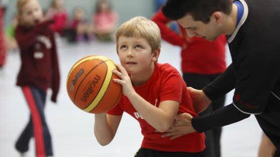 Murat Avcilar, der Jugendtrinaer bei den Coburger Basketballern, erläutert die richtige Wurftechnik.  Fotos: Katja Nauer