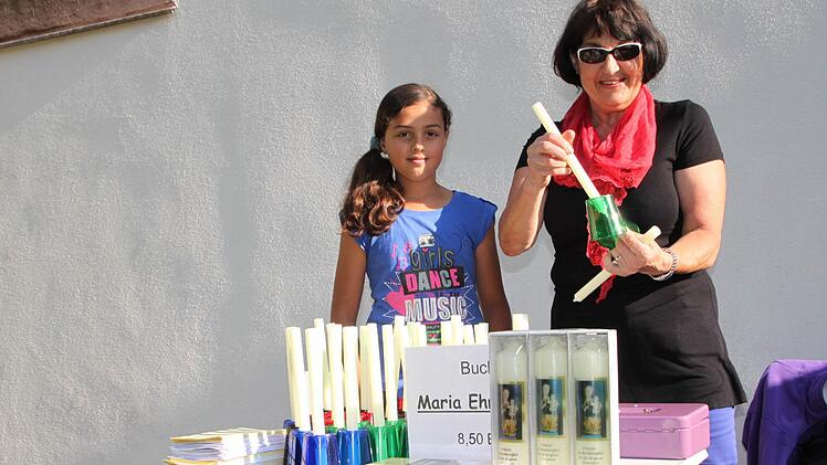 Marita Hüfner (rechts) vom Pfarrgemeinderat in Speicherz und Emma Leibold verkaufen Kerzen.