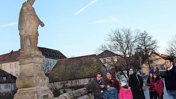Der neue Gästeführer Shadi Assad mit seiner Gruppe auf der alten Aischbrücke. Foto: Johanna Blum