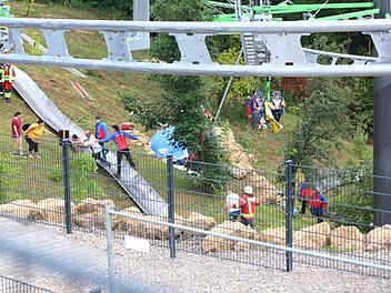 Bergwacht und Feuerwehr seilen Besucher aus der stehenden Gondelbahn der neuen Sommerrodelbahn ab. Foto: Markus Roider, dpa