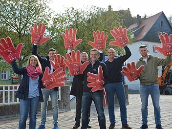 Winken für die Wanderer: Mit den übergroßen Fan-Händen dürfen Zuschauer die Teilnehmer des Frankenwald-Wandermarathons anfeuern. Tonja Süsser von der Touist-Info, Tobias Günther von der Pressestelle der Stadt, OB Henry Schramm, Organisationsleiter Markus Franz, TUV-Chef Helmut Völkl und Dominik Weichart von der Tourist-Info (von links) haben die Winkehände mit Vergnügen ausprobiert. Foto: Dagmar Besand