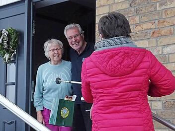 An einem Stock hängend überreichte Brigitte Ammon das "Can­dlelight-Dinner" mit Abstand an die beiden Gewinner Inge und Horst Nowotny.