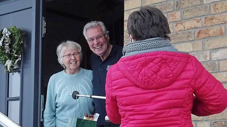 An einem Stock hängend überreichte Brigitte Ammon das "Can­dlelight-Dinner" mit Abstand an die beiden Gewinner Inge und Horst Nowotny.