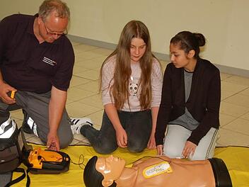 Burkard Kühn erklärt Emilia Kastl und Güller Babat die einzelnen Schritte zur Wiederbelebung.  Foto: Manfred Mellenthin