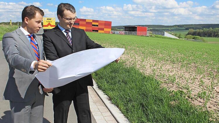 Vor einem Jahr stellten David Veit Krafft (links) und Matthias Gebhardt von der Geschäftsleitung der Dennert Poraver am Bauplatz ihre Pläne für das neue Werk in Schlüsselfeld vor. Hier soll Blähglasgranulat produziert werden. Im Hintergrund die Firma Pröls und der ADAC. Foto: Archiv