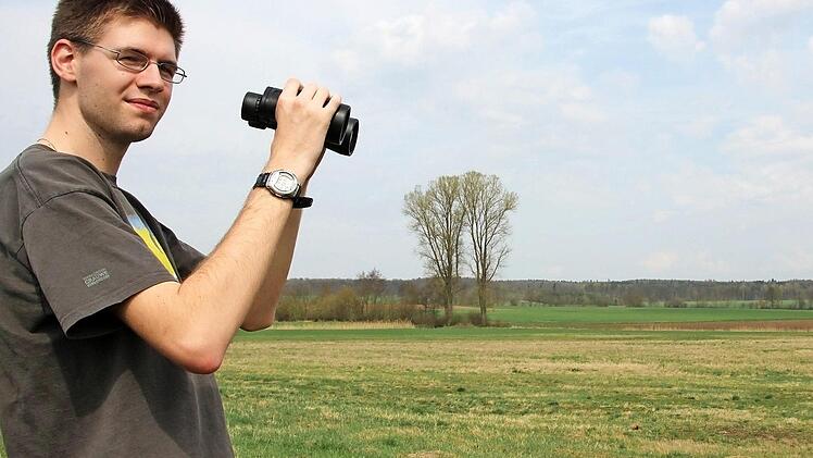 Matthias Franz ist viel mit Fernglas unterwegs, um Wiesenbrüter zu sichten. Ganz früh am Morgen ist die beste Zeit. Foto: Heike Beudert