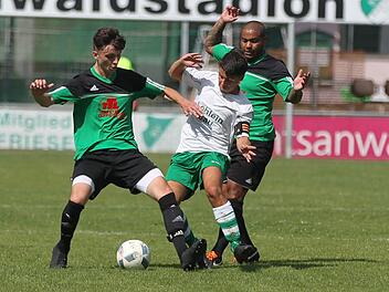 Friesens Kapit&auml;n Adrian Staufer (wei&szlig;es Trikot), der unmittelbar nach der Pause eine Ecke seines Spielertrainers Frank Fugmann bereits zum 3:0-Endstand eink&ouml;pfte, wird von den beiden "W&ouml;lfen" Tobias Dauer (links) und Claudio De Jesus Sabino bebr&auml;ngt. Foto: Lisa H&uuml;mmer