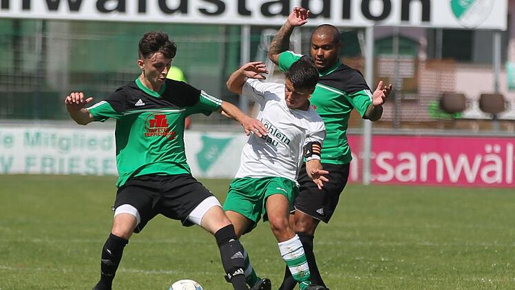 Friesens Kapit&auml;n Adrian Staufer (wei&szlig;es Trikot), der unmittelbar nach der Pause eine Ecke seines Spielertrainers Frank Fugmann bereits zum 3:0-Endstand eink&ouml;pfte, wird von den beiden "W&ouml;lfen" Tobias Dauer (links) und Claudio De Jesus Sabino bebr&auml;ngt. Foto: Lisa H&uuml;mmer