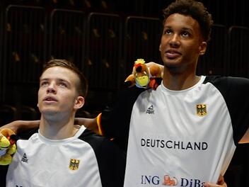 Der für Nürnberg in der zweiten Liga ProA spielende Bamberger Nils Haßfurther (links) und Louis Olinde von Brose Bamberg singen vor dem Spiel gegen Rumänien die deutsche Nationalhymne. Foto: Udo Schilling