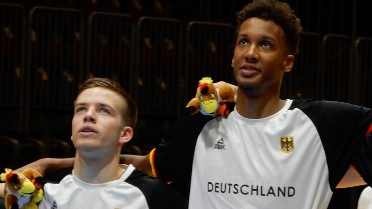 Der für Nürnberg in der zweiten Liga ProA spielende Bamberger Nils Haßfurther (links) und Louis Olinde von Brose Bamberg singen vor dem Spiel gegen Rumänien die deutsche Nationalhymne. Foto: Udo Schilling