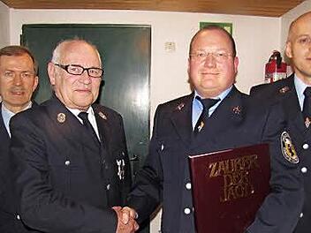 Vorsitzender Johannes Schulz ehrt seinen Stellvertreter Stefan Büttner, der auch Kommandant der aktiven Truppe ist, für 30 Jahre Mitgliedschaft in der Freiwilligen Feuerwehr Lützelbuch. Es gratulierten auch Kassierer Wolfgang Weber (links) und Schriftführer Burkhard Metze (rechts).  Foto: Martin Koch