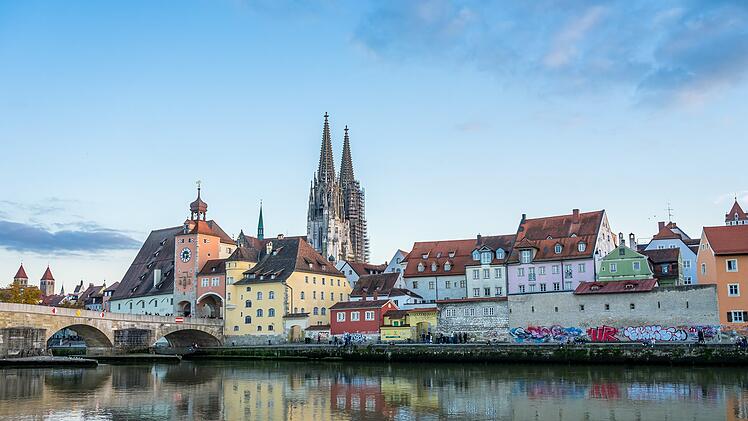 Historische Altstadt mit bunten H&auml;usern und einer beeindruckenden Kathedrale im Hintergrund, gespiegelt im ruhigen Fluss; eine fr&auml;nkische Stadt, ideal f&uuml;r Kurzurlaub.