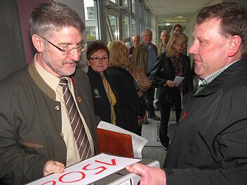 Jürgen Angermüller (rechts) überreicht einen Ordner mit 1508 Unterschriften gegen das "Grüne Band" an Landrat Michael Busch. Foto: Berthold Köhler