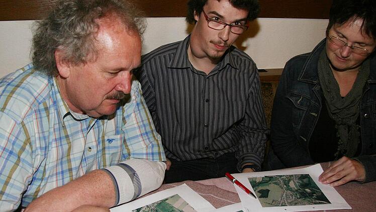 Max und Christoph Graß sowie Monika Müller (von links) studieren die Ortspläne der Marktgemeinde Marktschorgast. Alle drei kämpfen für ein Nahwärmenetz und sehen eine solche Gemeinschaftsanlage als Chance. Foto: Sonja Adam