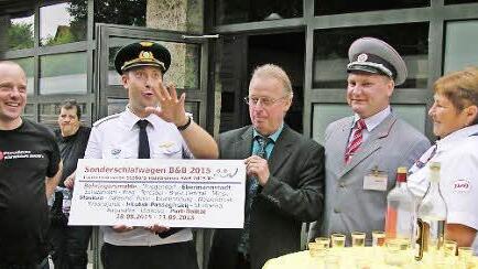 Die Organisatoren Matthias Meeh und Anton Tarasov (von links) übergeben unter Assistenz des RZD-Zugbegleitpersonals an Bürgermeister Helmut Taut ein Zuglaufschild. Fotos: Klaus Oelzner