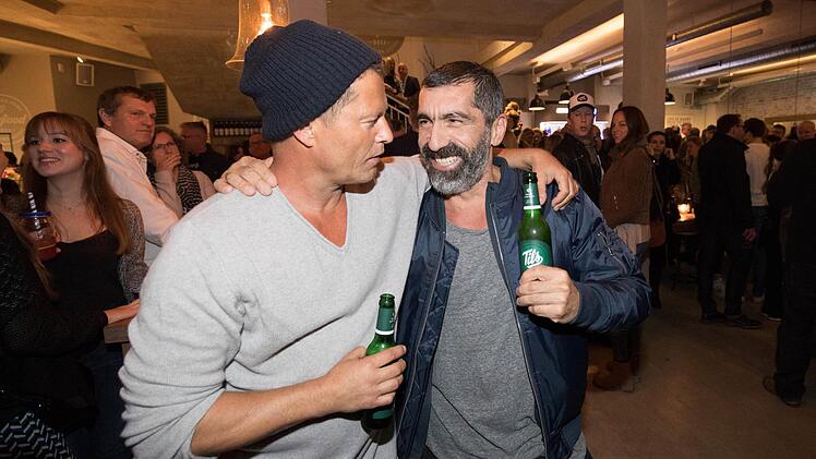 Til Schweiger und Schauspieler Erdal Yildiz (r) trinken am 02.11.2016 in Hamburg bei der Eröffnung des neuen Restaurants "Barefood Deli" von Schweiger ein Bier. Foto: Christian Charisius/dpa