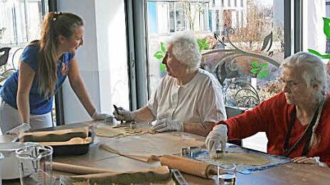Gemeinsames Kochen mit der Ergotherapeutin fördert und erhält die geistigen Fähigkeiten, die Koordination und das manuelle Geschick der Patienten. Ergotherapeutin Linda Gagel in der Weihnachtsbäckerei mit Ingrid Leitner und Anny Greiner (von links).  Foto: Marco Heumann
