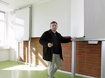 Schulleiter Jürgen Kretschmann zeigt in einem renovierten Klassenzimmer die neue Kombination aus Tafel und Beamer-Wand.  Fotos: Matthias Hoch