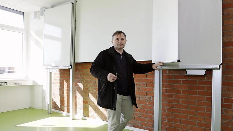 Schulleiter Jürgen Kretschmann zeigt in einem renovierten Klassenzimmer die neue Kombination aus Tafel und Beamer-Wand.  Fotos: Matthias Hoch