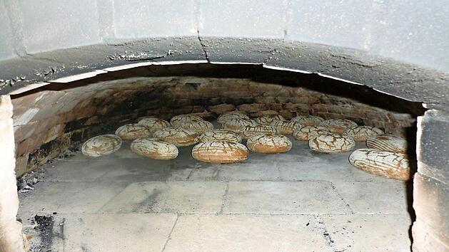 Vor der Wanderung wird der Ofen angeheizt. Wenn die Gruppe zur&uuml;ckkommt, wird das Brot eingeschossen.