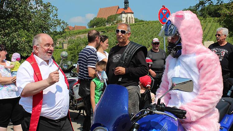 Pfarrer Hofmann segnet eine kostümierte Motorradfahrerin.
