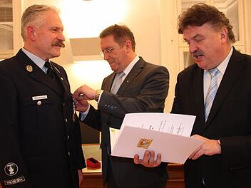 Seit 40 Jahren ist Manfred Täuber (links) aktiver Feuerwehrmann bei der Kulmbacher Wehr. Dafür ehrte ihn Oberbürgermeister Henry Schramm im Beisein von Landrat Klaus Peter Söllner (rechts) mit dem Staatlichen Ehrenkreuz in Gold.  Foto: Stephan Stöckel