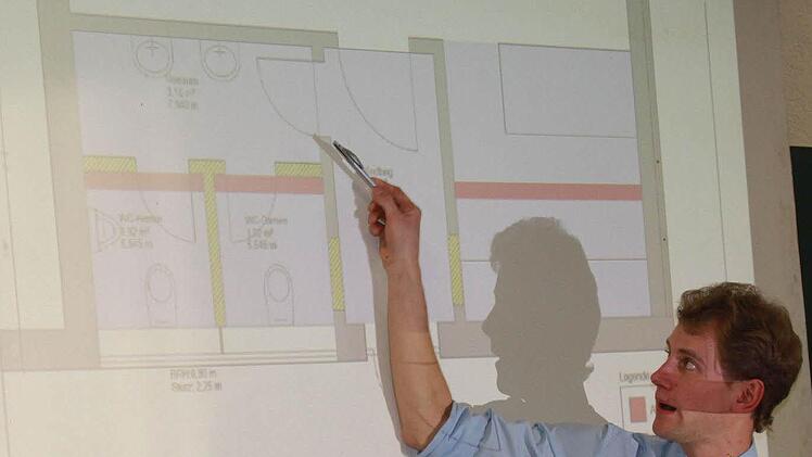 Der Vorsitzende des Feuerwehrvereins, Anton Gerstenkorn, stellte den Plan für die neue Raumsituation vor. Die rot markierten Wände werden entfernt, gelb markierte Wände werden neu errichtet. So soll der gesamte Toilettenbereich freundlicher und angenehmer gestaltet werden. Foto: Katharina Becht