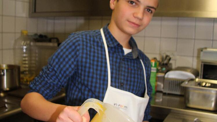 Mikhail Vassilyev (14) hilft zu Hause auch hin und wieder beim Kochen - er portioniert bei der Essensausgabe am Tag der Schulverpflegung.