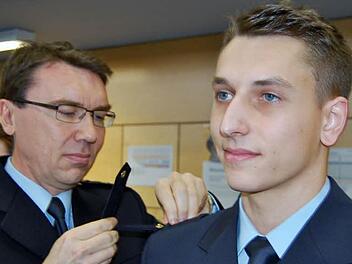 Traumziel erreicht: Polizeidirektor Thomas Lehmann legt dem Lehrgangsbesten Pascal Nordgauer die neue Schulterklappe des Polizeimeisters an. Foto: Sigismund von Dobschütz
