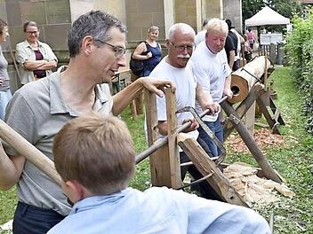 Franz und sein Vater halfen tatkräftig mit beim Holzstammdurchbohren des Arbeitskreises Heimat und Geschichte. Damit wurde gezeigt, wie früher Wasserleitungen aus Holz hergestellt worden sind.  Fotos: Gerold Snater