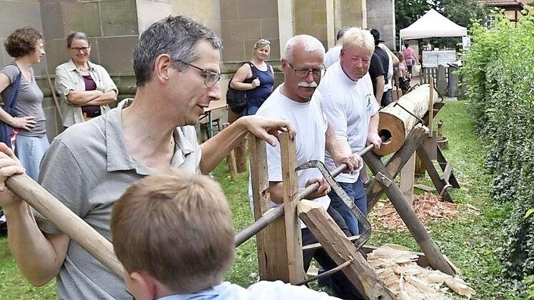 Franz und sein Vater halfen tatkräftig mit beim Holzstammdurchbohren des Arbeitskreises Heimat und Geschichte. Damit wurde gezeigt, wie früher Wasserleitungen aus Holz hergestellt worden sind.  Fotos: Gerold Snater