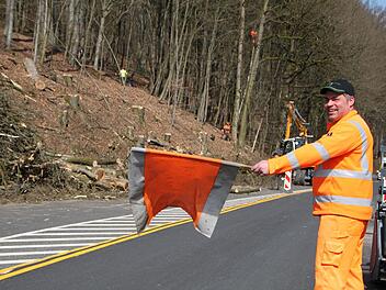 Markus Hildmann von der Straßenmeisterei Hammelburg sichert die Straße während der Holzfällarbeiten. Foto: Ulrike Müller