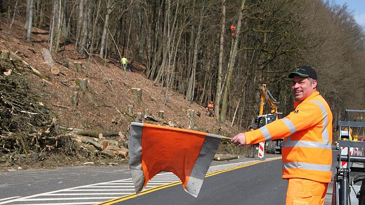 Markus Hildmann von der Straßenmeisterei Hammelburg sichert die Straße während der Holzfällarbeiten. Foto: Ulrike Müller